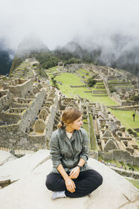 Full length of woman sitting on mountain