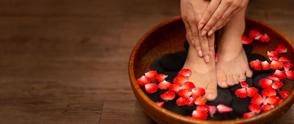 Midsection of woman with strawberries in bowl on table