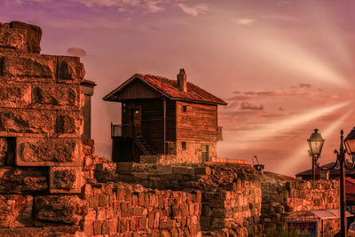 Houses against sky during sunset