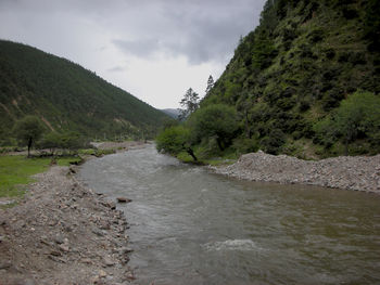 Scenic view of river amidst mountains against sky