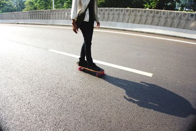 Low section of person with umbrella on road