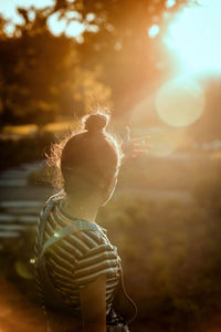 Rear view of child standing on land against sky