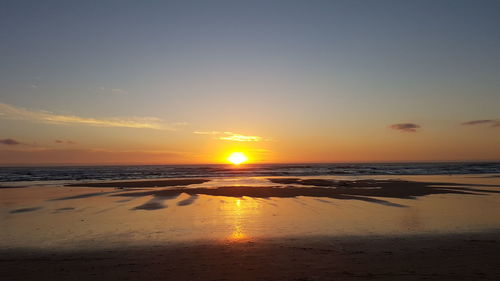 Scenic view of beach against sky during sunset