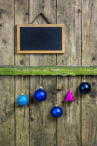 Christmas ornaments with blackboard hanging on wooden fence