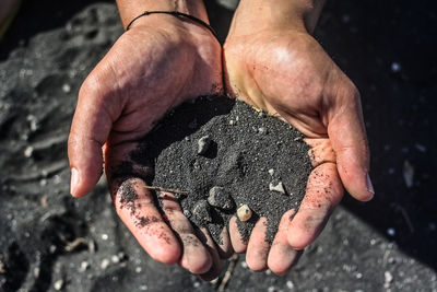 Cropped hand holding black sand