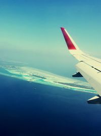 Close-up of airplane wing against clear blue sky