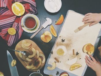 Cropped hands of woman by food and drink on table