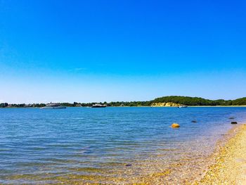 Scenic view of sea against clear blue sky