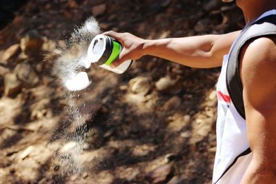 Midsection of man throwing talcum powder on field