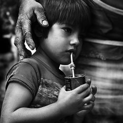 Close-up of boy with father holding cup