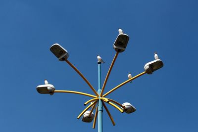 Low angle view of street light against blue sky