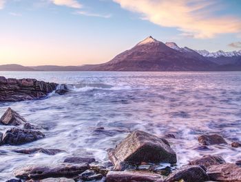 Evening rocky shore with sea water and large cracked rocks with erosion marks. rocky coast with sea