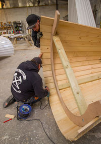 High angle view of people sitting on wood