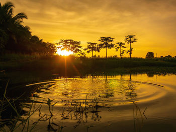 Scenic view of lake against orange sky