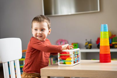 Portrait of cute boy playing with toy blocks at home
