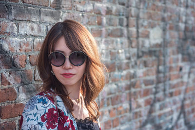 Portrait of woman standing against wall