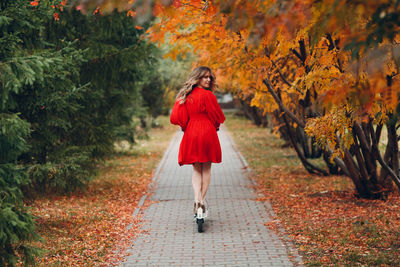Full length of woman walking on footpath during autumn