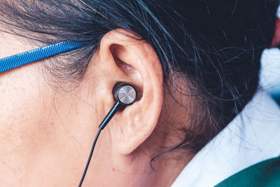 Close-up of person listening music through headphones