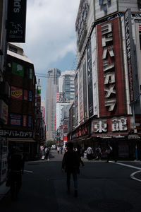 People on road in city against sky