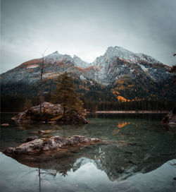 Scenic view of lake by mountains against sky