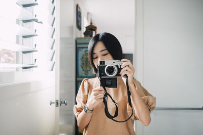 Young woman photographing with camera