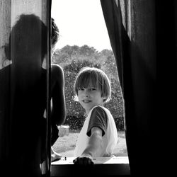 Portrait of boy sitting in window