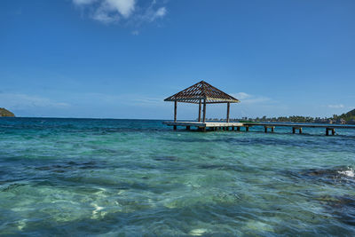 Lifeguard hut on beach against blue sky