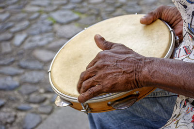 Hands and instrument of percussionist playing tambourine in the streets of pelourinho, salvador city