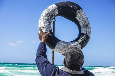 Rear view of man standing at beach