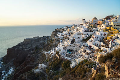 Aerial view of buildings by sea against sky