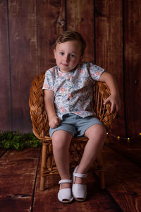 Portrait of boy sitting on hardwood floor