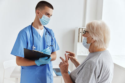 Doctor wearing mask examining patient at clinic