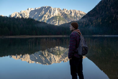 Rear view of man standing by lake