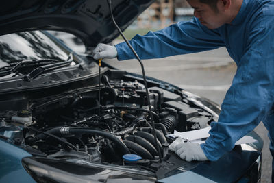 Side view of man repairing car