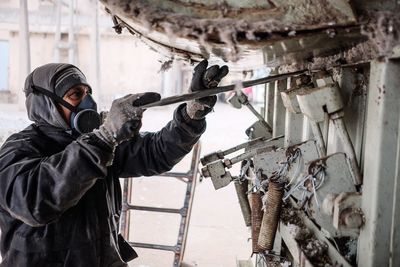 Side view of man working in factory