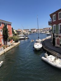 Sailboats moored in canal against buildings in city