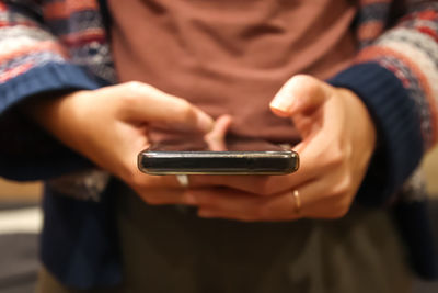 Midsection of man using mobile phone