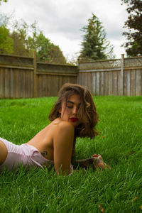 Portrait of young woman on grass in field