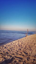 Scenic view of beach against blue sky