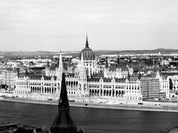 View of buildings and river against sky in city