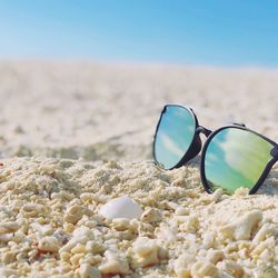 Close-up of sunglasses on beach