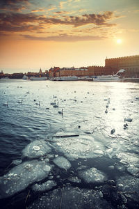 Scenic view of frozen river against sky during sunset