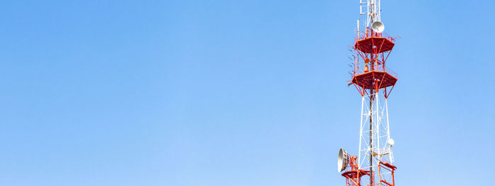 Low angle view of ferris wheel against clear blue sky