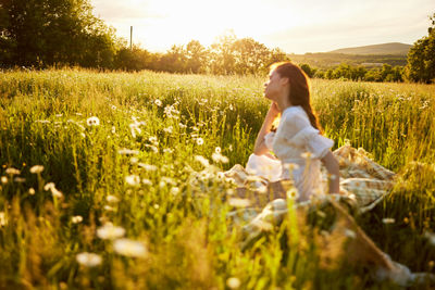 Rear view of woman sitting on grassy field