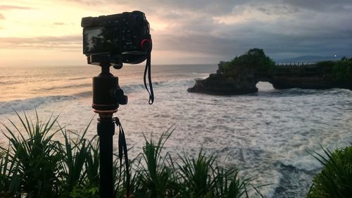 Man photographing at beach against sky