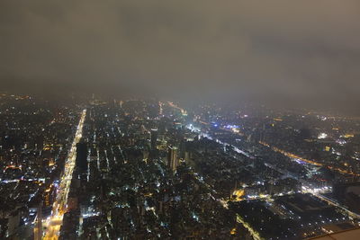 Illuminated cityscape against sky at night