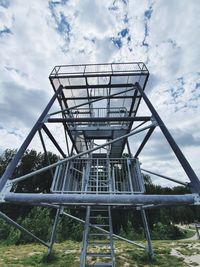 Low angle view of metal structure on field against sky