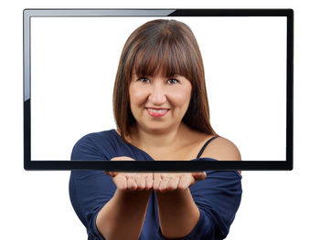 Portrait of smiling young woman using phone against white background