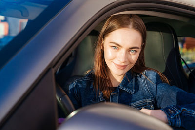 Beautiful young lady happy car. cute girl who drives car and smiles. portrait