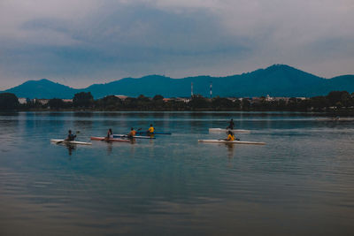 People in lake against sky